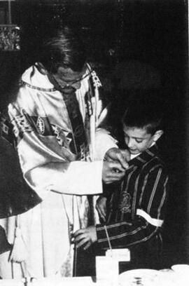 1992 Father Brewer helping a communicant with his pin